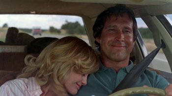 Movie still from “Vacation” (1983), directed by Harold Ramis – A man and a woman sitting in the back seat of a car; Close Up shot, Low angle