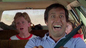 Movie still from “Vacation” (1983), directed by Harold Ramis – A man and a boy in the back seat of a car; Close Up shot, Low angle