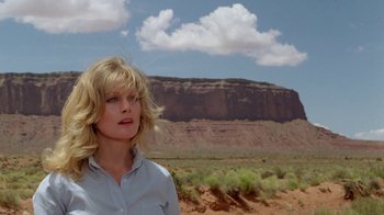 Movie still from “Vacation” (1983), directed by Harold Ramis – A woman standing in front of a desert landscape; Close Up shot, Low angle