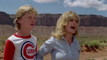 Movie still from “Vacation” (1983), directed by Harold Ramis – A woman and a young boy standing next to each other in the desert; Medium shot, Low angle