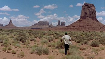Movie still from “Vacation” (1983), directed by Harold Ramis – A man walking through a field in the middle of the desert; Extreme Wide shot, Over the shoulder angle