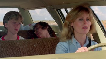 Movie still from “Vacation” (1983), directed by Harold Ramis – A man and a woman in the back seat of a car; Medium shot, Over the shoulder angle