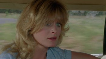 Movie still from “Vacation” (1983), directed by Harold Ramis – A person in a car looking at the camera; Close Up shot, Over the shoulder angle