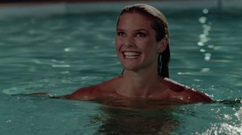 Movie still from “Vacation” (1983), directed by Harold Ramis – A woman in the water smiling for the camera; Close Up shot, High angle