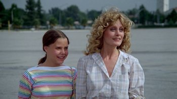 Movie still from “Vacation” (1983), directed by Harold Ramis – A woman standing next to a young girl in front of a body of water; Medium shot, Low angle