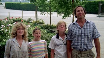 Movie still from “Vacation” (1983), directed by Harold Ramis – A group of people standing next to each other near trees; Medium shot, Low angle