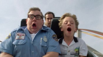Movie still from “Vacation” (1983), directed by Harold Ramis – A man and two boys riding on a roller coaster; Close Up shot, Low angle