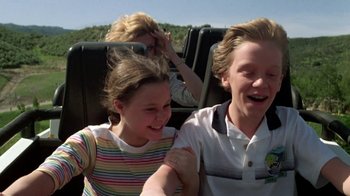 Movie still from “Vacation” (1983), directed by Harold Ramis – Two young people laughing while sitting on a bus; Medium shot, Over the shoulder angle