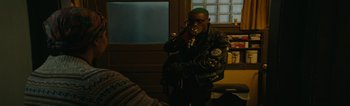 A man smoking a cigarette while wearing a leather jacket