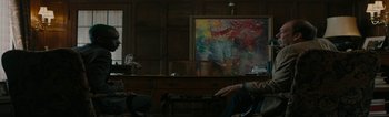 A person sitting in front of a painting in a room