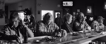Movie still from “Nebraska” (2013), directed by Alexander Payne – An older man sitting at a bar with a beer in front of him; Medium shot, Over the shoulder angle