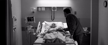 Movie still from “Nebraska” (2013), directed by Alexander Payne – An older man is in a hospital bed with a younger man; Medium shot, Over the shoulder angle