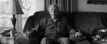 Movie still from “Nebraska” (2013), directed by Alexander Payne – An older man sitting on a couch in a living room; Close Up shot, Low angle