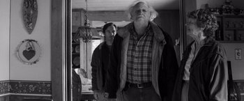 Movie still from “Nebraska” (2013), directed by Alexander Payne – An older man and a young woman standing in a kitchen; Medium shot, Low angle