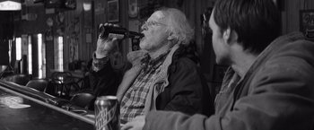 Movie still from “Nebraska” (2013), directed by Alexander Payne – An older man drinking a beer while sitting next to a younger man; Medium shot, Over the shoulder angle