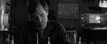 Movie still from “Nebraska” (2013), directed by Alexander Payne – A man sitting at a table with two beer bottles; Close Up shot, Low angle