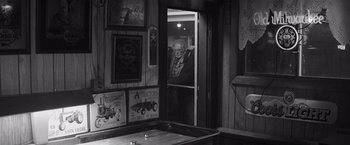 Movie still from “Nebraska” (2013), directed by Alexander Payne – An old man standing in a doorway of a restaurant; Wide shot, Over the shoulder angle