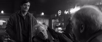 Movie still from “Nebraska” (2013), directed by Alexander Payne – An older man sitting in a chair in a room; Medium shot, Low angle