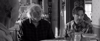 Movie still from “Nebraska” (2013), directed by Alexander Payne – An older man sitting at a table with a glass of wine; Close Up shot, Over the shoulder angle
