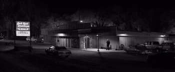 Movie still from “Nebraska” (2013), directed by Alexander Payne – A man standing in front of a building at night; Extreme Wide shot, Low angle