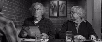 Movie still from “Nebraska” (2013), directed by Alexander Payne – A man and a woman sitting at a dinner table; Medium shot, Over the shoulder angle