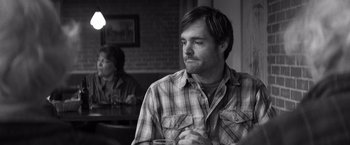 Movie still from “Nebraska” (2013), directed by Alexander Payne – A black and white photo of a man sitting at a table; Close Up shot, Over the shoulder angle