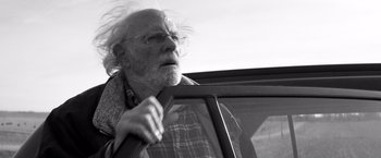 Movie still from “Nebraska” (2013), directed by Alexander Payne – An old man with a beard and glasses leaning on the window of a car; Close Up shot, Low angle