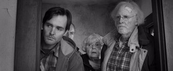 Movie still from “Nebraska” (2013), directed by Alexander Payne – A group of people standing next to each other in a room; Medium shot, Over the shoulder angle