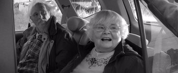 Movie still from “Nebraska” (2013), directed by Alexander Payne – An older woman sitting in the back seat of a car; Close Up shot, Over the shoulder angle