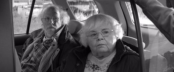 Movie still from “Nebraska” (2013), directed by Alexander Payne – An older woman and a younger man sitting in the back of a car; Close Up shot, Over the shoulder angle