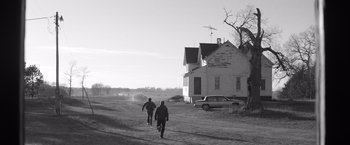 Movie still from “Nebraska” (2013), directed by Alexander Payne – Two people walking down a dirt road near a house; Extreme Wide shot, Low angle