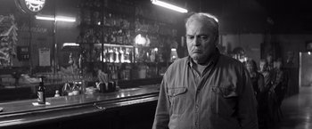 Movie still from “Nebraska” (2013), directed by Alexander Payne – An older man standing in front of a bar; Medium shot, Low angle