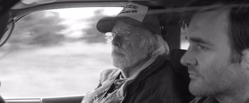 Movie still from “Nebraska” (2013), directed by Alexander Payne – An older man wearing a hat sitting in the back of a car; Close Up shot, Over the shoulder angle