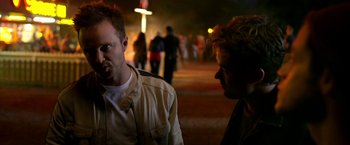 Movie still from “Need for Speed” (2014), directed by Scott Waugh – Two people standing on a sidewalk at night; Close Up shot, Over the shoulder angle