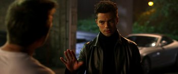 Movie still from “Need for Speed” (2014), directed by Scott Waugh – A man in a leather jacket holding out his hand; Close Up shot, Over the shoulder angle