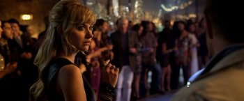 Movie still from “Need for Speed” (2014), directed by Scott Waugh – A woman is standing in front of a group of people; Close Up shot, Over the shoulder angle