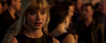 Movie still from “Need for Speed” (2014), directed by Scott Waugh – A woman's face in front of other women; Close Up shot, Over the shoulder angle