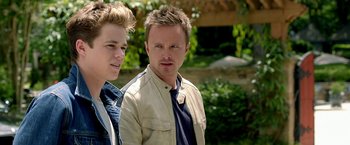 Movie still from “Need for Speed” (2014), directed by Scott Waugh – Two young men standing next to each other in front of trees; Close Up shot, Over the shoulder angle