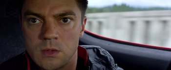 Movie still from “Need for Speed” (2014), directed by Scott Waugh – A man's face while driving a car; Close Up shot, Over the shoulder angle