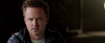 Movie still from “Need for Speed” (2014), directed by Scott Waugh – A person wearing a leather jacket; Close Up shot, Over the shoulder angle