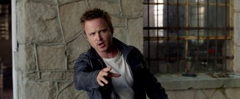 Movie still from “Need for Speed” (2014), directed by Scott Waugh – A man in a leather jacket pointing to the side; Close Up shot, Over the shoulder angle