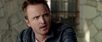 Movie still from “Need for Speed” (2014), directed by Scott Waugh – A person wearing a leather jacket; Close Up shot, Over the shoulder angle