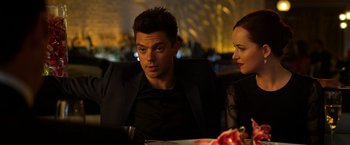 Movie still from “Need for Speed” (2014), directed by Scott Waugh – A man and a woman sitting at a dinner table; Medium shot, Over the shoulder angle