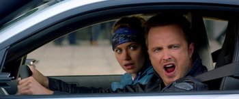 Movie still from “Need for Speed” (2014), directed by Scott Waugh – A man and a woman in the back seat of a car; Close Up shot, Over the shoulder angle