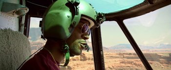 Movie still from “Need for Speed” (2014), directed by Scott Waugh – A man wearing a helmet looking out of a helicopter window; Close Up shot, Over the shoulder angle