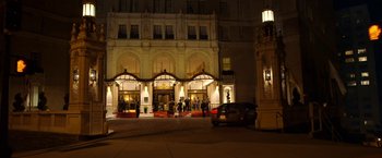 Movie still from “Need for Speed” (2014), directed by Scott Waugh – A car parked on the side of the road in front of a building at night; Extreme Wide shot, Low angle