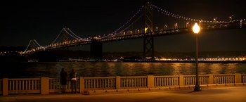 Movie still from “Need for Speed” (2014), directed by Scott Waugh – Two people sitting on a bench near a body of water at night; Extreme Wide shot, High angle