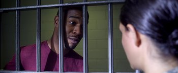 Movie still from “Need for Speed” (2014), directed by Scott Waugh – A man in a jail cell looking at another man; Close Up shot, Over the shoulder angle