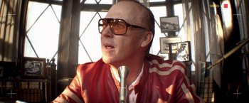 Movie still from “Need for Speed” (2014), directed by Scott Waugh – A man in a red jacket is talking into a microphone; Close Up shot, Low angle