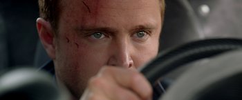 Movie still from “Need for Speed” (2014), directed by Scott Waugh – A person holding a cell phone; Close Up shot, Over the shoulder angle